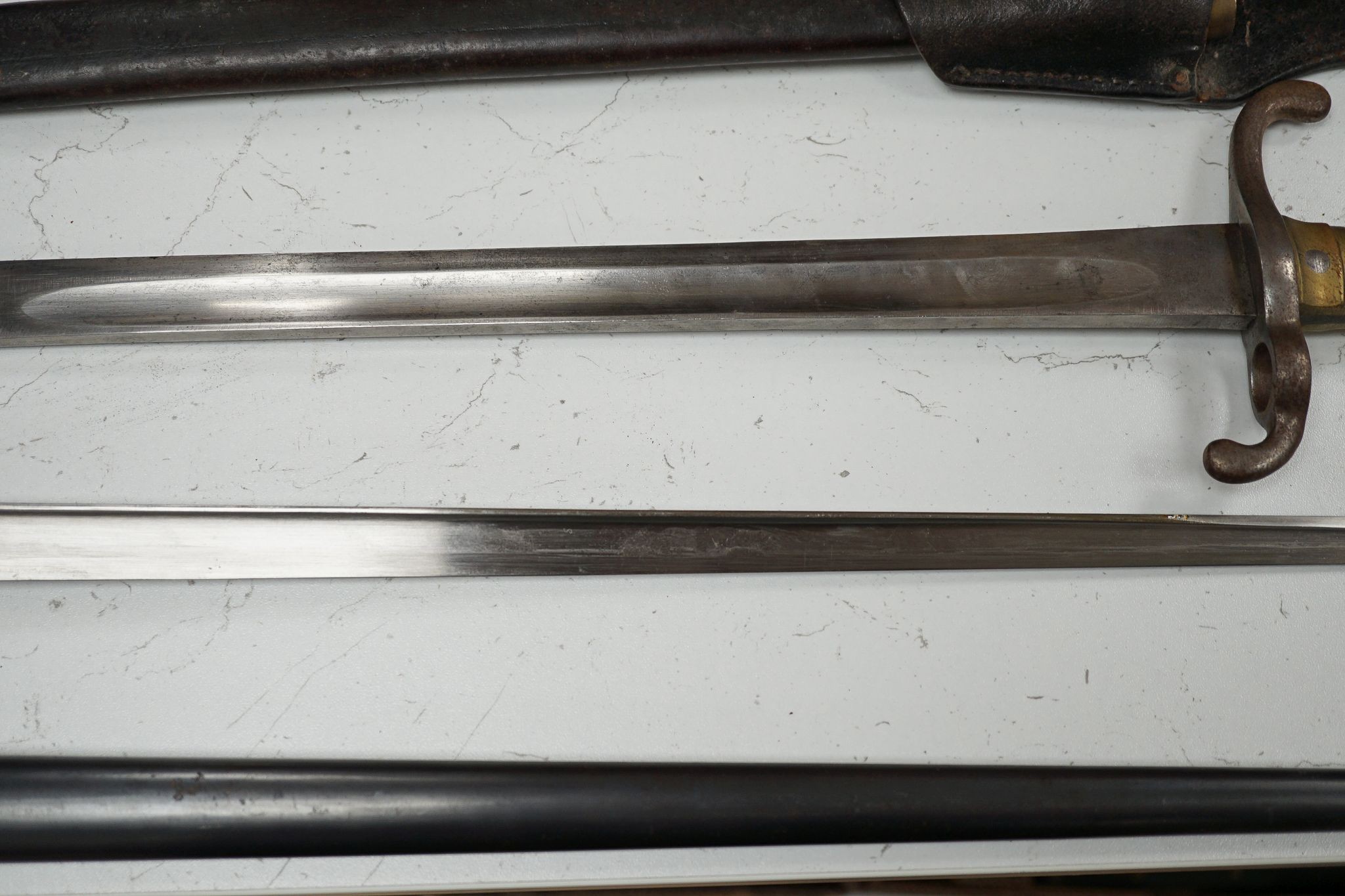 A French bayonet and scabbard with matching serial number (38804) and inscription and date to back of blade (1879) and another Solingen bayonet and scabbard